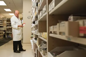 a warehouse manager in a lab coat checking stocks