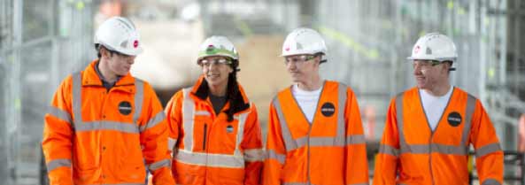 four osbore employees walking on site wearing orange hi-vis suites and protective hats