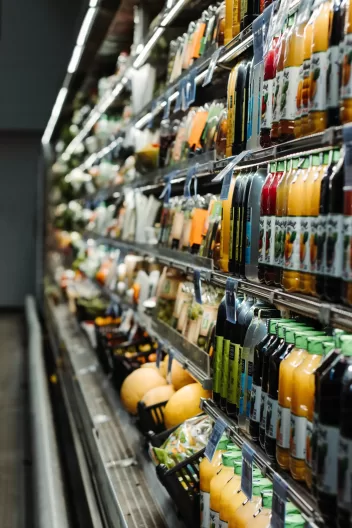 a supermarket fridge with drinks and fruit